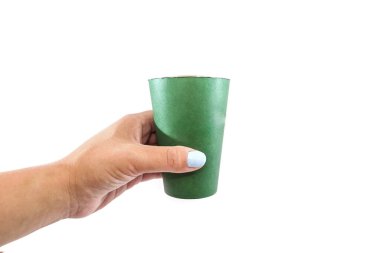 Beyaz arka planda izole edilmiş kadın elinde yeşil kağıt bardak. Boşluğu kopyala.