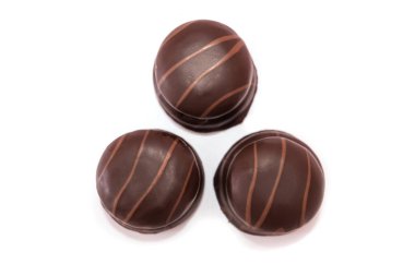 Beyaz arka planda izole edilmiş üç çikolata şekeri. Yukarıdan görüntüle.