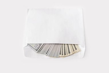Beyaz arka planda beyaz bir zarfta 100 dolarlık banknotlar.