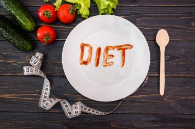 Ölçüm bandıyla çeşitli sebzeler ve ahşap zemin üzerinde 