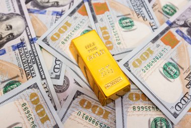 Dolar arkaplanındaki altın külçeler. Zenginlik kavramı.