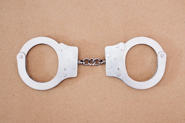 Top View Gray Metal Handcuffs Brown Background — Stock Photo, Image
