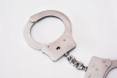 Beyaz arka planda gri metal kelepçeler. Suç kavramı.