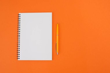 Fotokopi alanı olan turuncu arkaplanlı bir not defteri. Düz yatıyordu.