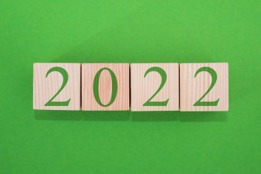 Soyut tasarım konsepti - 2022. Yeşil arkaplanda küpleri olan yeni yıl hedef planı, üst görünüm.