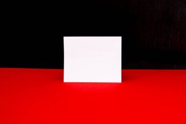 Kırmızı-siyah arkaplanda boş beyaz etiket. Boş bir kağıt parçası. Metnin için yer.