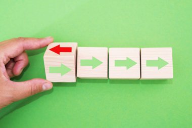 Elinle tahta bloğu çevir. Kırmızı ok ters yöne baksın. Siyah oklar, Eşsiz, farklı düşün, bireysel ve kalabalığın konseptinden uzak dur.