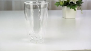 Su büyük şeffaf bir bardağa dökülür..