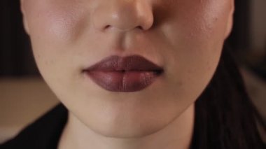 Genç bir bayanın dudakları. Parlak bordo dudaklar..