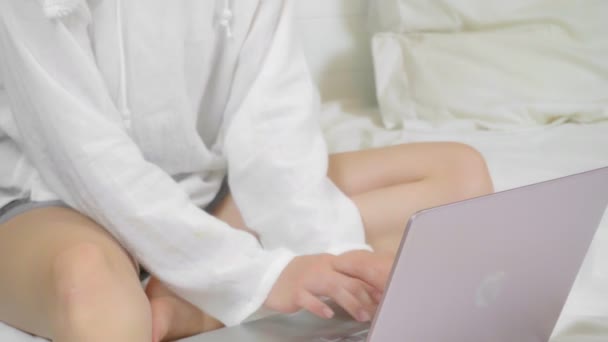 自宅のベッドに座っている間 ラップトップコンピュータを使用している若い女性 ノートパソコンのキーボードを閉じる — ストック動画