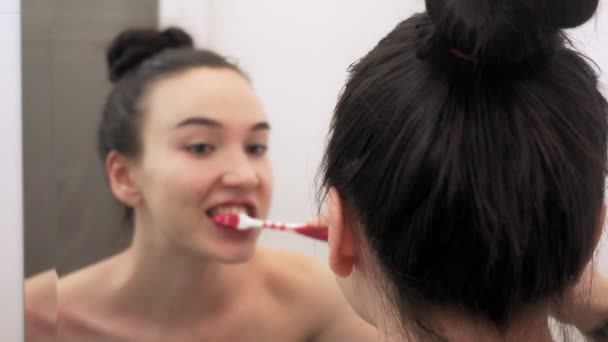 Young Woman Brushing Her Teeth Bathroom Portrait Mirror Image — Stock Video