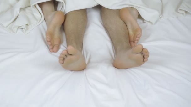 愛を作るベッドのカップル 雪の白いベッドの上の男性と女性の足 上からの眺め セックス4K — ストック動画