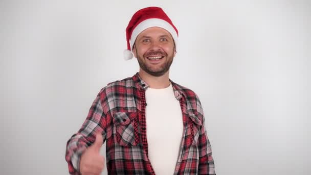 サンタ・クラスの帽子の男が親指を立ててる。コロナウイルスのパンデミックを祝う — ストック動画