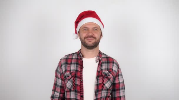 Noel Baba şapkalı bir adam el sallar ve selamlar. — Stok video