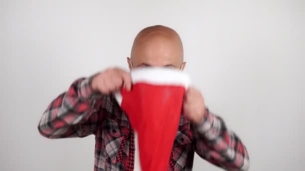 Bir adam Noel Baba şapkası takar ve dans eder.. — Stok video