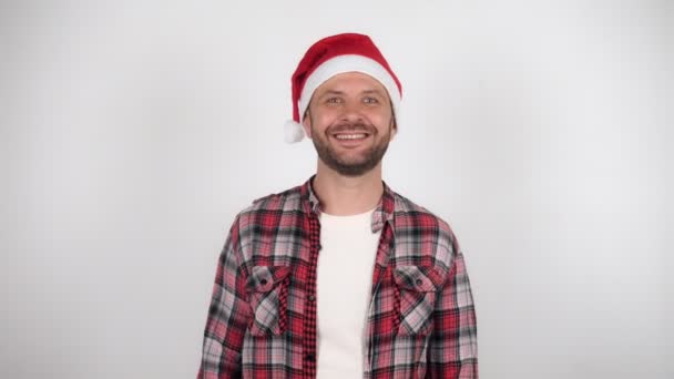 Un uomo con un cappello da Babbo Natale saluta e saluta. — Video Stock