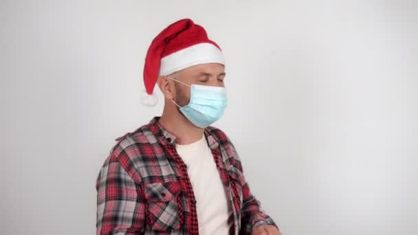 Seorang pria dengan topi Santa dan topeng medis menari — Stok Video