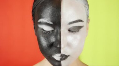 Siyah beyaz makyajlı genç bir kadın kameraya bakıyor. Parlak renkli arka plan. - Evet. Yüksek kalite 4k görüntü