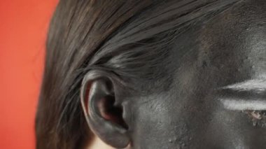 Siyah beyaz makyajlı genç bir kadın kameraya bakıyor. Parlak renkli arka plan. - Evet. Yüksek kalite 4k görüntü