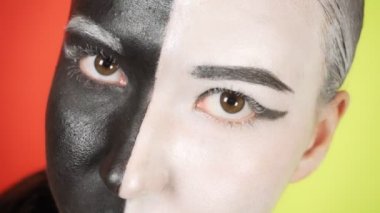 Siyah beyaz makyajlı genç bir kadın kameraya bakıyor. Parlak renkli arka plan. - Evet. Yüksek kalite 4k görüntü