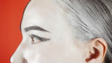 Siyah beyaz makyajlı genç bir kadın kameraya bakıyor. Parlak renkli arka plan. - Evet. Yüksek kalite 4k görüntü