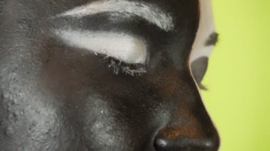 Siyah beyaz makyajlı genç bir kadın kameraya bakıyor. Parlak renkli arka plan. - Evet. Yüksek kalite 4k görüntü