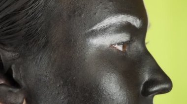 Siyah beyaz makyajlı genç bir kadın kameraya bakıyor. Parlak renkli arka plan. - Evet. Yüksek kalite 4k görüntü