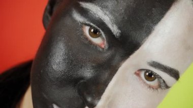 Siyah beyaz makyajlı genç bir kadın kameraya bakıyor. Parlak renkli arka plan. - Evet. Yüksek kalite 4k görüntü