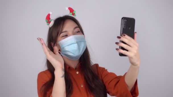 Mujer Con Adornos Árbol Navidad Pelo Una Máscara Médica Charlando — Vídeos de Stock