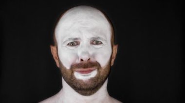 Beyaz maskeli bir pandomimci duyguları betimler. Siyah arka plandaki adam. Yüksek kalite 4k görüntü