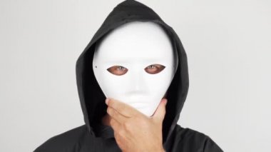 Korkunç tiyatro maskeli bir adam kameraya bakıyor. Bir adam maskesini çıkardı ve çılgın bir bakışla kameraya baktı. Manyak. Cadılar Bayramı konsepti