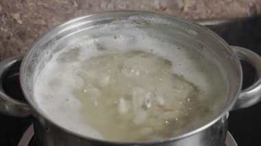 Fasulye Pişirme Süreci beyaz fasulye tohumları bir tencerede kaynar su içinde. Yüksek kalite 4k görüntü