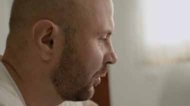 Evdeki kel sakallı adam video aracılığıyla iletişim kuruyor. Yüz profili yakın plan. Kilitli adam evden çalışıyor. Tam HD görüntüler