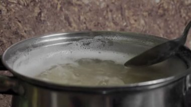 Fasulye Pişirme Süreci Bir tencerede kaynar suda beyaz fasulye tohumları.
