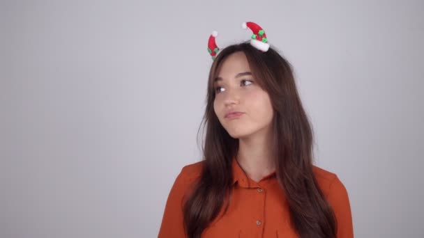 Young woman with Christmas decorations in her hair puts on a medical mask — Stock Video