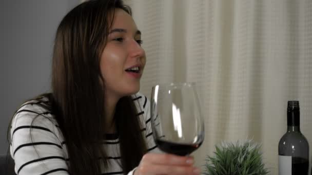 Un uomo e una donna stanno bevendo vino a tavola a casa. Ambiente romantico — Video Stock