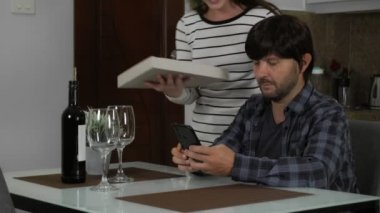 Evde pizza ve kırmızı şarapla randevusu olan genç bir çift. 4k görüntü