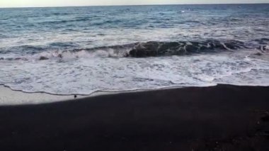 Siyah volkanik plajdaki deniz dalgalarının görüntüsü