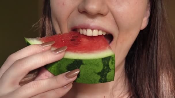 Extreme close-up van een aantrekkelijke schattig brunette jonge vrouw eten van een watermeloen. — Stockvideo