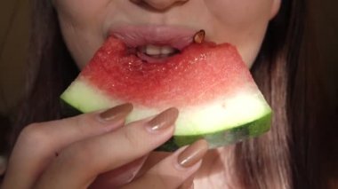 Karpuz yiyen çekici, tatlı, genç bir kadının aşırı yakın çekimi..