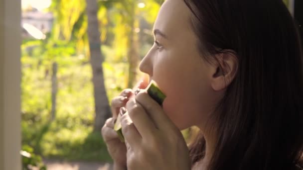 Close-up van een aantrekkelijke schattig brunette jonge vrouw eten een watermeloen. — Stockvideo