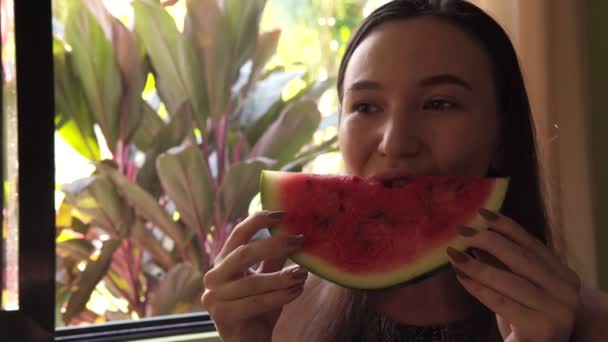 Close-up van een aantrekkelijke schattig brunette jonge vrouw eten een watermeloen. — Stockvideo