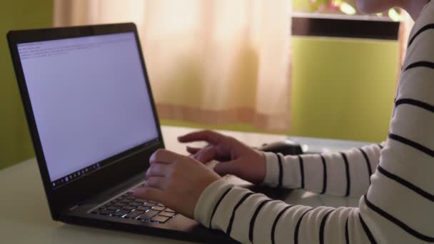 Seorang wanita pekerja lepas duduk di meja dan mengerjakan laptop. — Stok Video