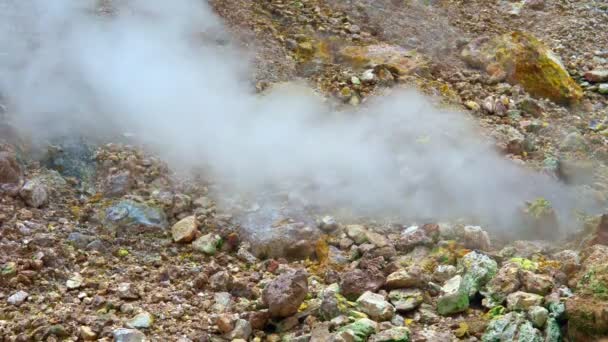 Fontes termais sulfúricas de origem vulcânica. O vapor sai das pedras vermelhas. — Vídeo de Stock