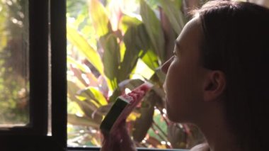 Çekici, tatlı, esmer, karpuz yiyen genç bir kadının yakın çekimi..