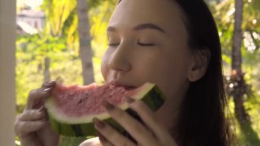 Çekici, tatlı, esmer, karpuz yiyen genç bir kadının yakın çekimi..