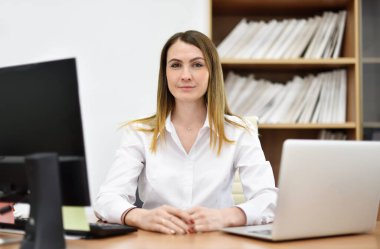 Ofisindeki masasında orta yaşlı kadın ofis yöneticisi portresi.