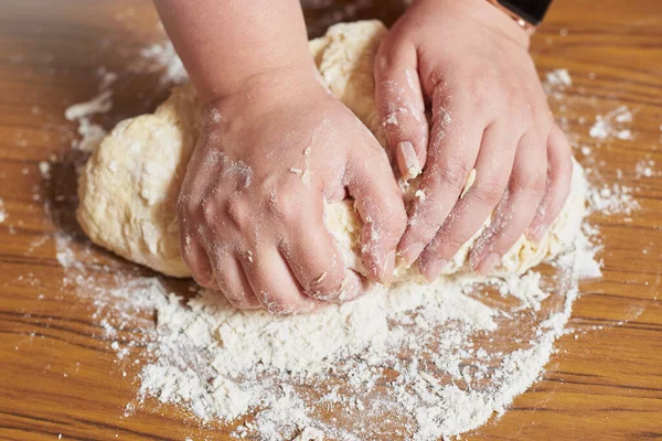 Blisko żeńskich rąk ugniatających ciasto w domu — Zdjęcie stockowe