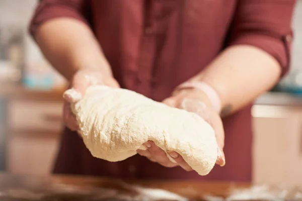 Kobiece ręce trzymające wykończone surowe ciasto z bliska — Zdjęcie stockowe