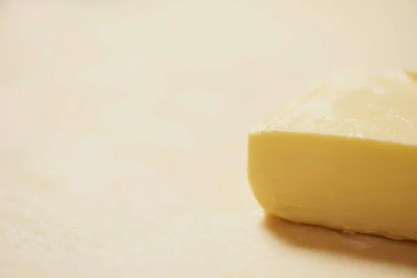 Close-up of a piece of butter is on the rolled raw dough — Stock Photo, Image